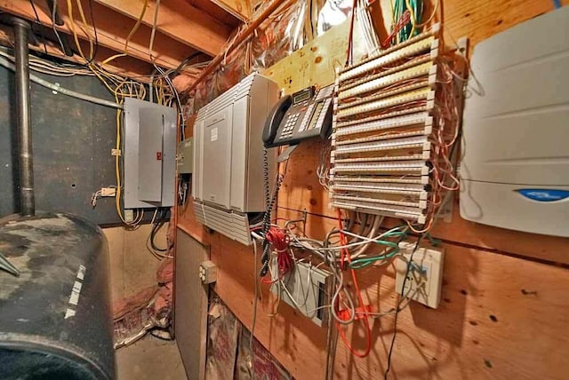 utility room featuring electric panel, heating fuel, and water heater