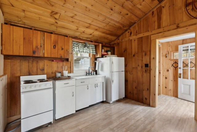 kitchen with lofted ceiling, white appliances, wooden walls, wood ceiling, and a sink