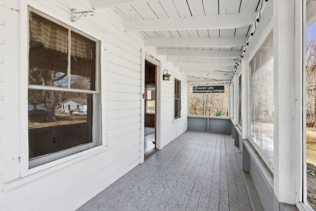 unfurnished sunroom with beamed ceiling