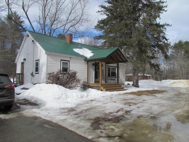 view of front of home with metal roof and a chimney