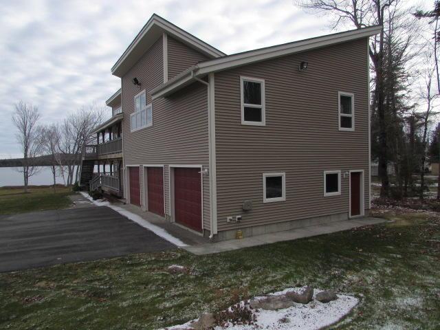 view of side of property featuring aphalt driveway and an attached garage