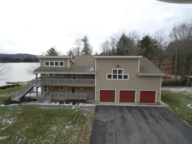 view of front of house with a front yard, driveway, stairway, and an attached garage