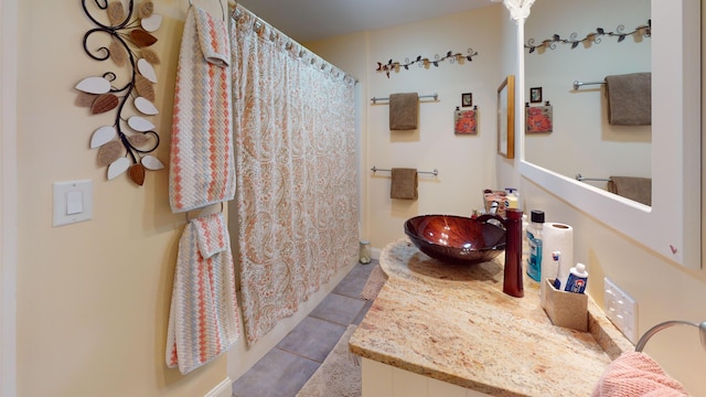 bathroom with a shower with curtain, a sink, and tile patterned floors