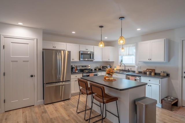 46 Firefly Ln, Bangor, ME 04401 - kitchen with stainless steel appliances, dark countertops, white cabinets, a kitchen bar, and recessed lighting