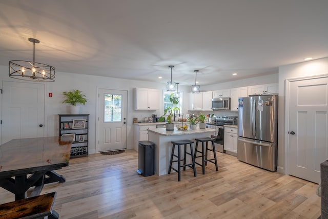 46 Firefly Ln, Bangor, ME 04401 - kitchen featuring appliances with stainless steel finishes, a kitchen island, white cabinets, recessed lighting, and a kitchen breakfast bar
