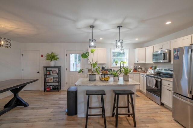 46 Firefly Ln, Bangor, ME 04401 - kitchen with stainless steel appliances, white cabinets, recessed lighting, a kitchen island, and light wood-type flooring