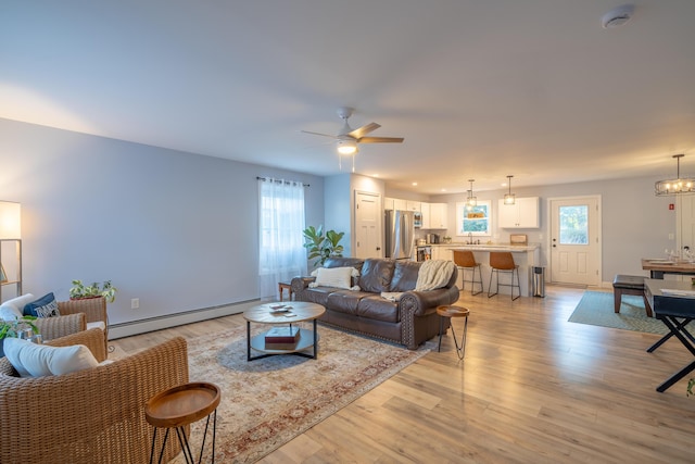 46 Firefly Ln, Bangor, ME 04401 - living room featuring a baseboard radiator, light wood-style flooring, and healthy amount of natural light