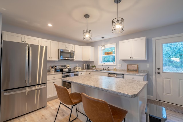 46 Firefly Ln, Bangor, ME 04401 - kitchen featuring stainless steel appliances, light countertops, a breakfast bar area, healthy amount of natural light, and recessed lighting