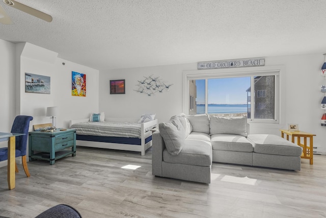 bedroom featuring a ceiling fan, a textured ceiling, and wood finished floors