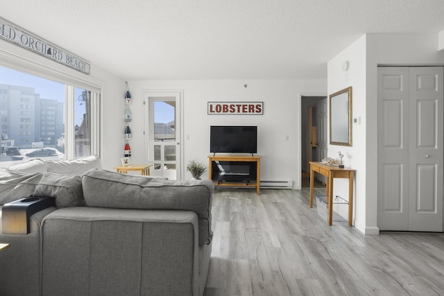 living area with light wood finished floors and a textured ceiling