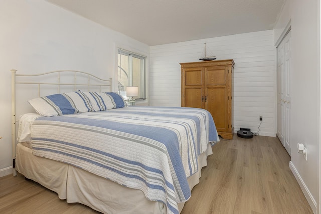 bedroom with light wood-style flooring and baseboards