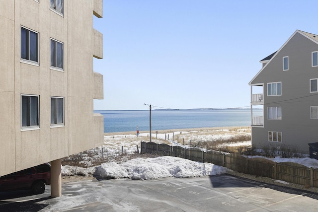 property view of water featuring fence and a view of the beach