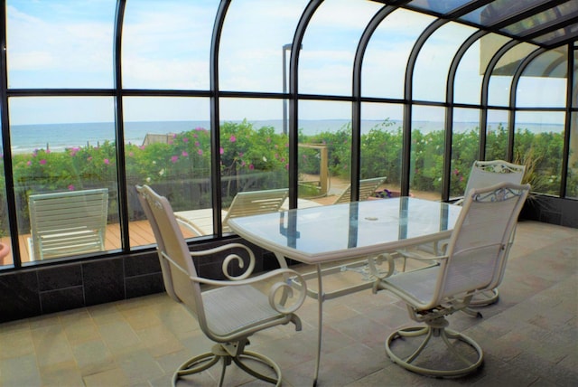 sunroom / solarium featuring a water view