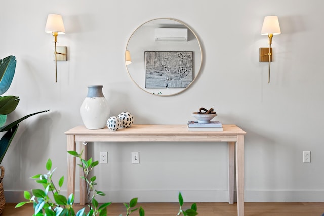 interior details with a wall unit AC and wood finished floors