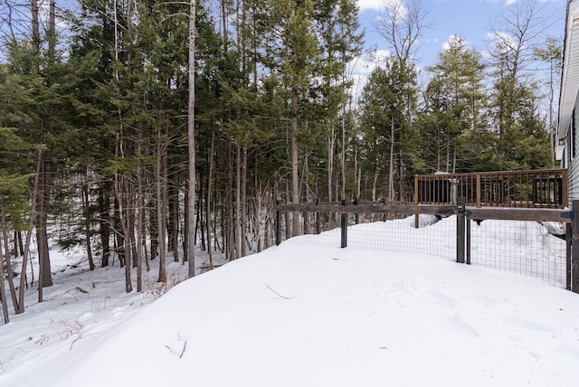 yard covered in snow with a deck