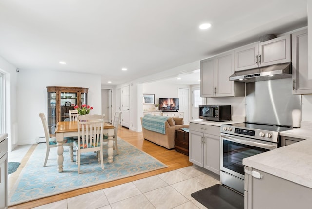 kitchen with gray cabinets, under cabinet range hood, recessed lighting, appliances with stainless steel finishes, and light countertops