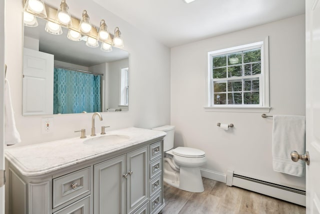 full bath featuring toilet, a baseboard heating unit, wood finished floors, baseboards, and vanity