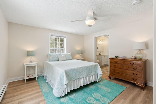 bedroom with ensuite bathroom, a textured ceiling, light wood-style floors, baseboards, and baseboard heating