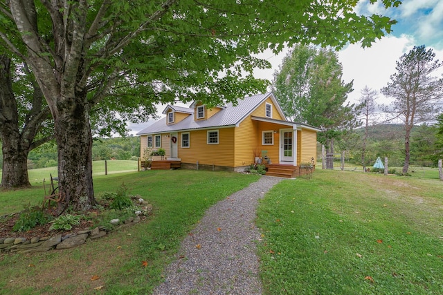 view of front of house featuring a front lawn, driveway, and metal roof