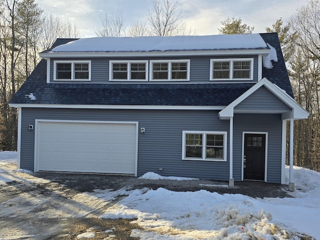 view of front of property featuring a garage and a shingled roof