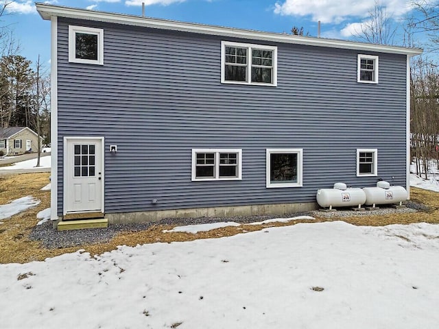 snow covered rear of property with entry steps