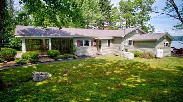 ranch-style house with a chimney and a front yard