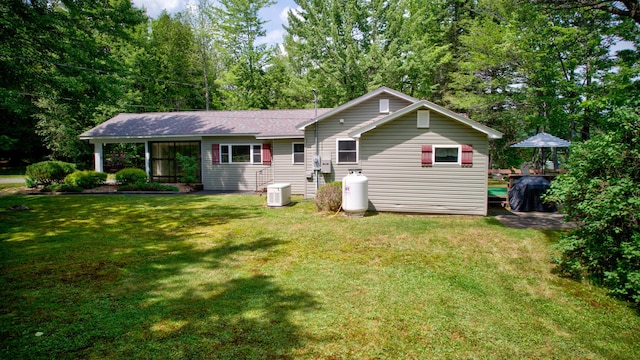 view of front of house featuring a front lawn and cooling unit