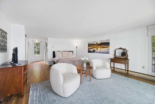 bedroom featuring baseboard heating and wood finished floors