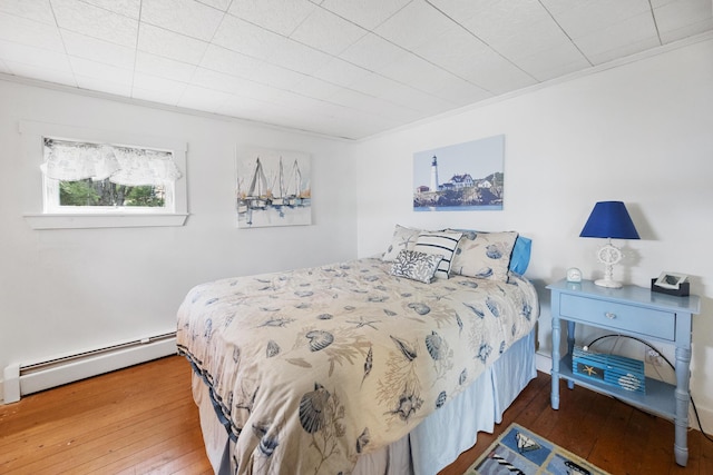 bedroom featuring ornamental molding, a baseboard radiator, and hardwood / wood-style flooring