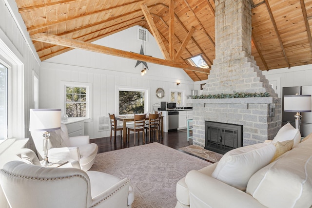 living area with vaulted ceiling with skylight, visible vents, wood ceiling, wood finished floors, and a brick fireplace