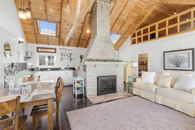 living room featuring a skylight, wooden ceiling, a fireplace, and dark wood-style flooring