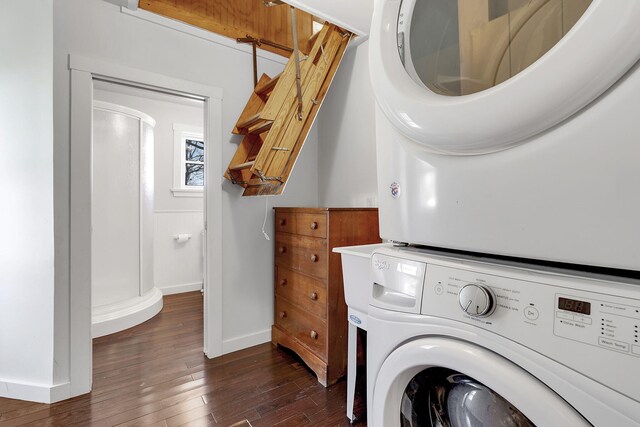 laundry area with laundry area, baseboards, dark wood-type flooring, and stacked washer and clothes dryer