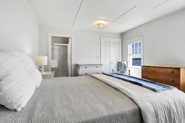 bedroom featuring a paneled ceiling, a closet, and connected bathroom