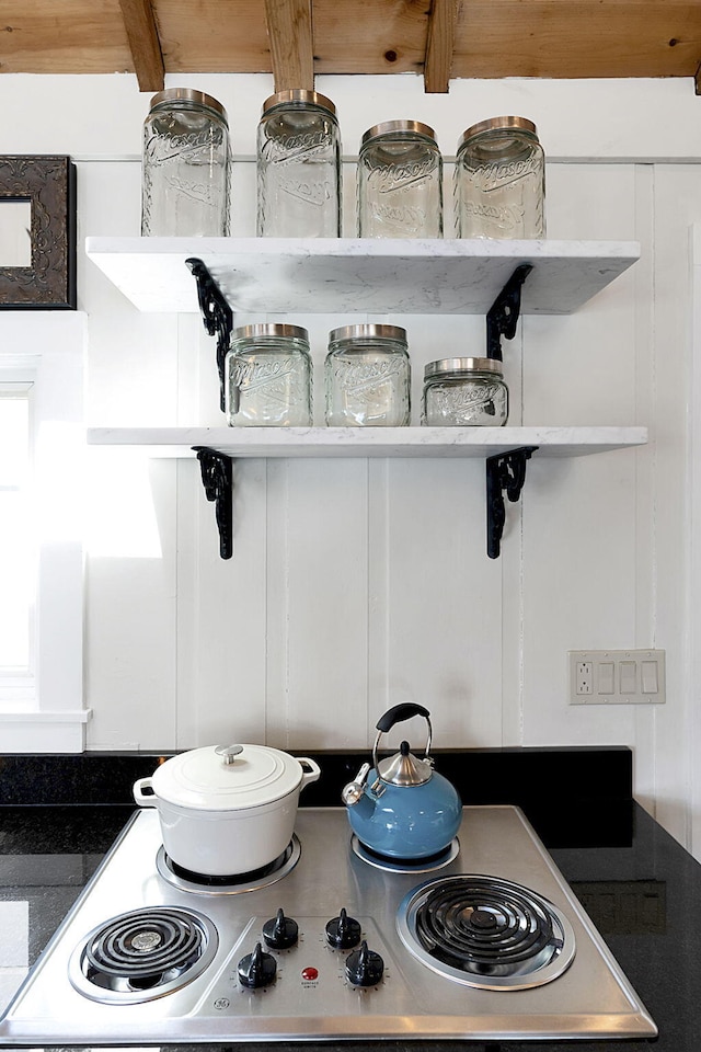 details featuring stainless steel electric cooktop, dark countertops, stove, and open shelves