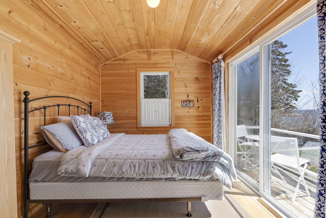 bedroom featuring lofted ceiling, wooden walls, wood ceiling, and multiple windows