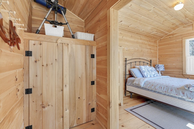 bedroom featuring lofted ceiling, wood-type flooring, wood ceiling, and wooden walls