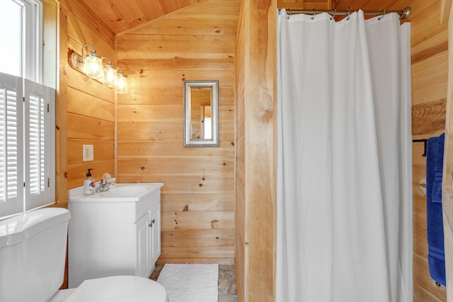 bathroom featuring lofted ceiling, curtained shower, toilet, wood walls, and vanity