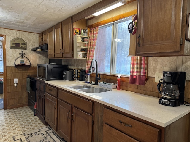 51 N Guilford Rd, Monson, ME 04464 - kitchen featuring plenty of natural light, black microwave, light countertops, brown cabinets, and a wainscoted wall