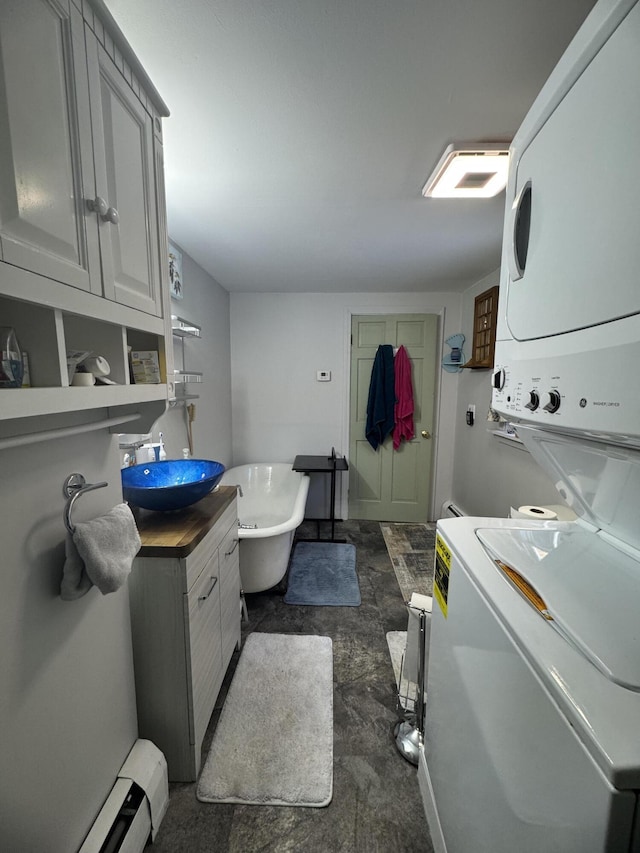51 N Guilford Rd, Monson, ME 04464 - laundry room featuring stacked washer / dryer and a baseboard heating unit
