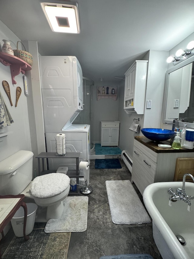 51 N Guilford Rd, Monson, ME 04464 - bathroom featuring stacked washer / drying machine, a freestanding tub, a baseboard heating unit, vanity, and concrete floors