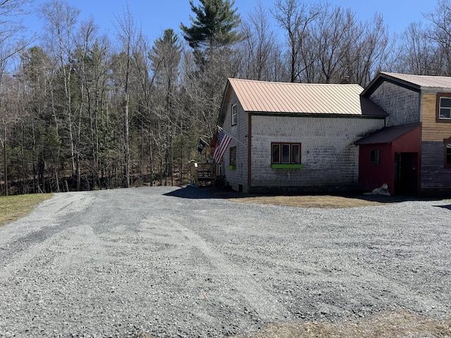 51 N Guilford Rd, Monson, ME 04464 - view of side of home with a metal roof, driveway, and brick siding