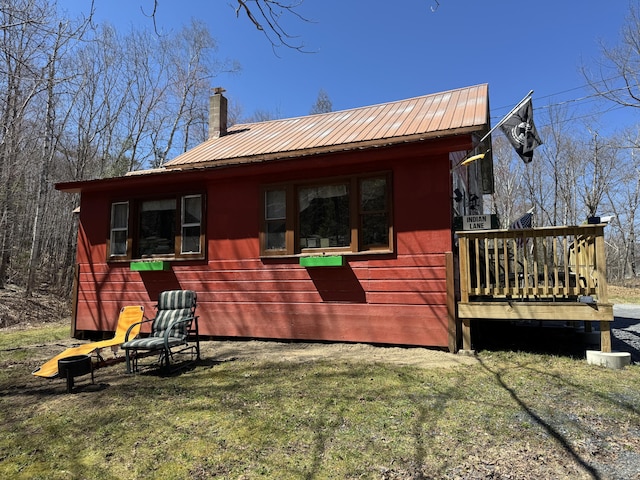 51 N Guilford Rd, Monson, ME 04464 - view of home's exterior with a metal roof, a chimney, a lawn, and a deck
