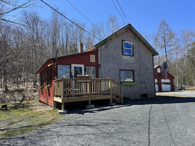 51 N Guilford Rd, Monson, ME 04464 - view of side of home featuring a chimney, a wooden deck, and a detached garage