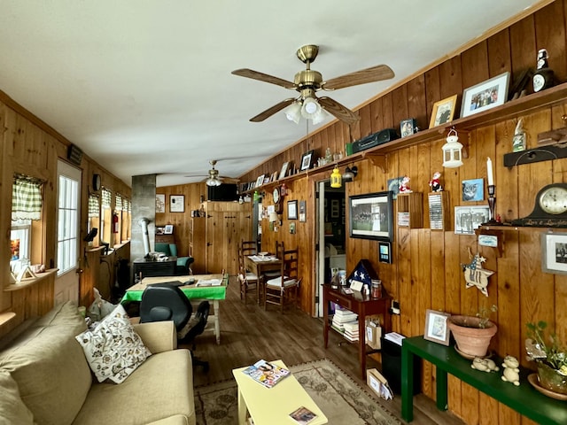 living area with wood finished floors, wood walls, and ceiling fan