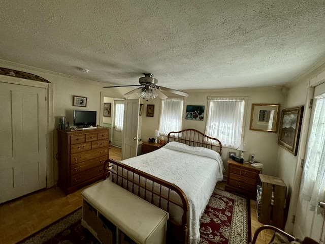 bedroom with crown molding, multiple windows, a ceiling fan, and a textured ceiling