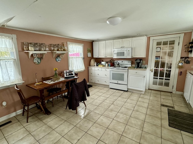 kitchen with visible vents, white appliances, white cabinets, light tile patterned floors, and baseboards