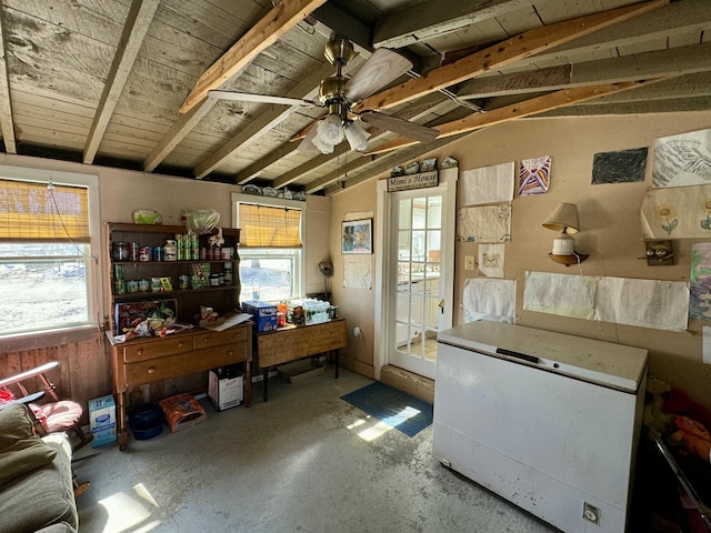 home office featuring lofted ceiling, concrete floors, and ceiling fan