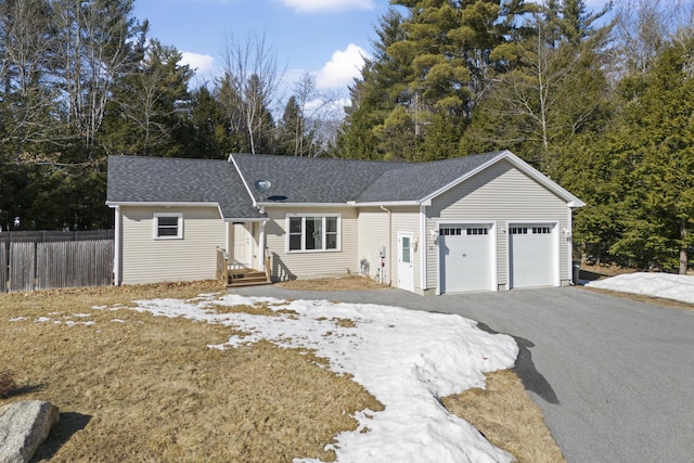 ranch-style house featuring aphalt driveway, roof with shingles, a garage, and fence