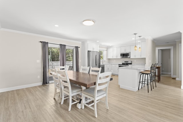 dining area featuring recessed lighting, light wood-style flooring, baseboards, and ornamental molding