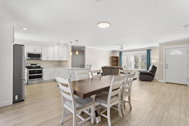 dining space with light wood-style flooring, recessed lighting, and baseboards